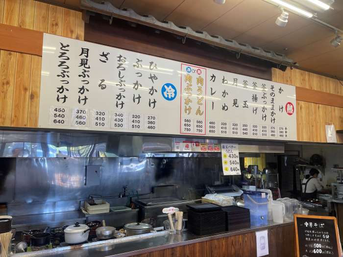 豊富なうどんメニューが揃うセルフ形式の注文カウンター。冷たいメニューやぶっかけうどんも充実。